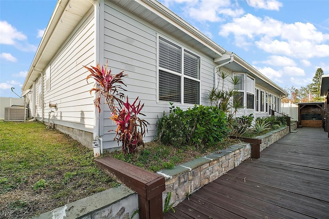 view of side of property featuring a lawn and central AC unit