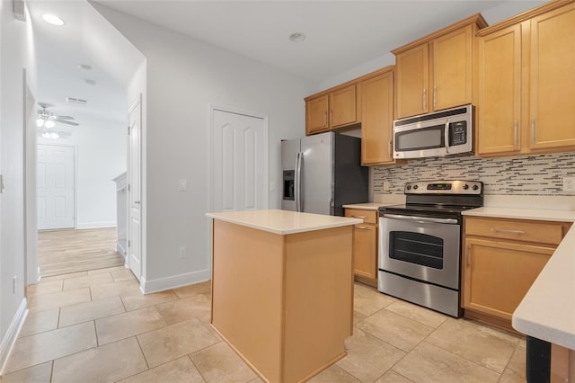 kitchen with stainless steel appliances, tasteful backsplash, a kitchen island, and ceiling fan