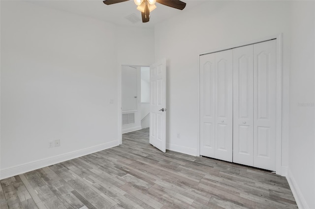 unfurnished bedroom featuring light hardwood / wood-style flooring, a closet, and ceiling fan