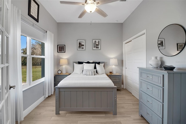 bedroom with multiple windows, ceiling fan, and light hardwood / wood-style floors