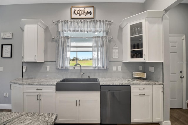 kitchen with white cabinetry, sink, light stone counters, and dishwasher