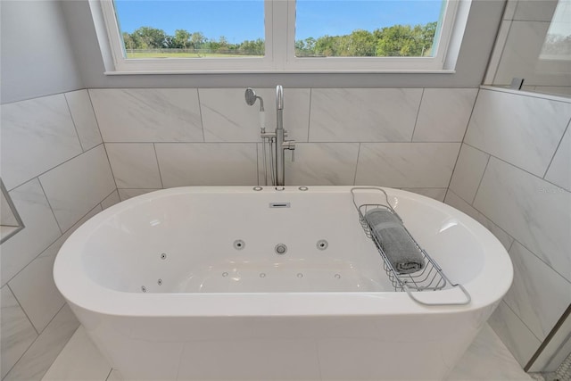 bathroom featuring a bathtub and tile walls