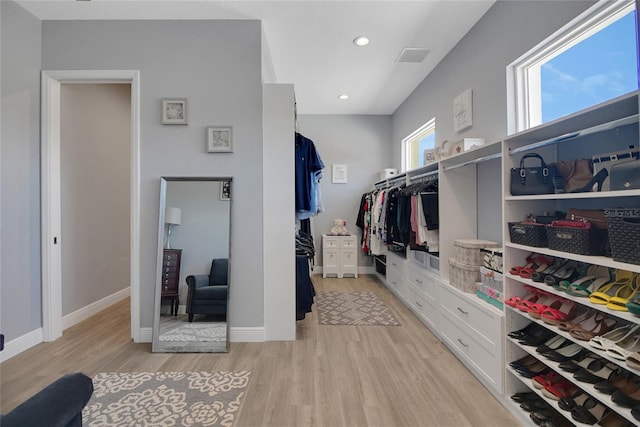 walk in closet with light hardwood / wood-style floors