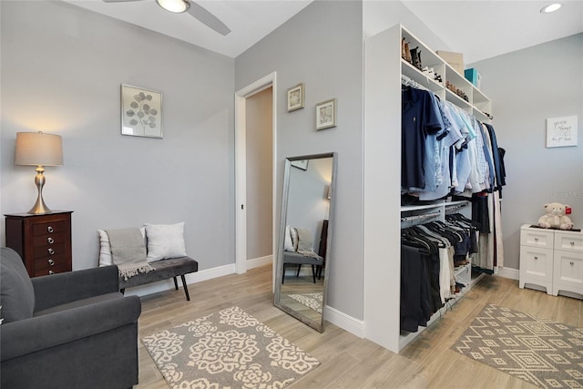 walk in closet with ceiling fan and light wood-type flooring