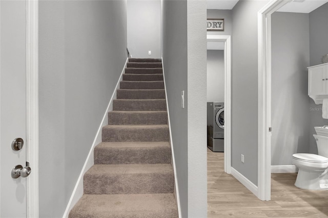 stairway with washer / clothes dryer and hardwood / wood-style floors