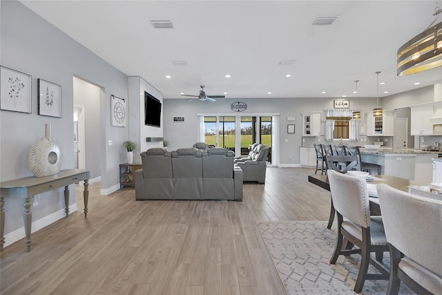 living room featuring ceiling fan and light hardwood / wood-style floors