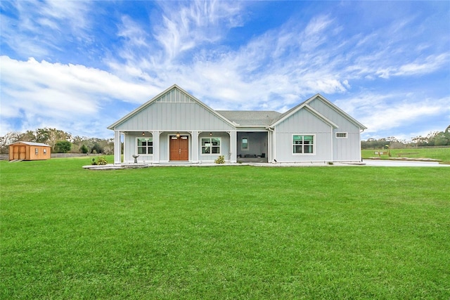 view of front of house featuring a storage shed, a front lawn, and covered porch