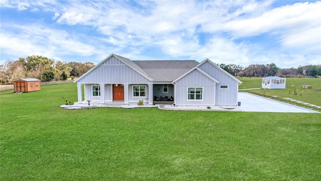 modern farmhouse with a porch, a shed, and a front lawn