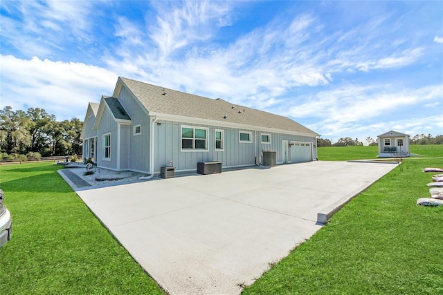 back of property with a garage and a lawn