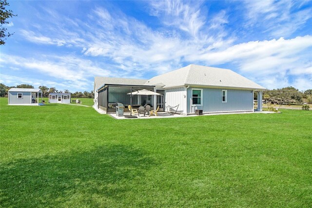 rear view of property featuring a patio and a lawn