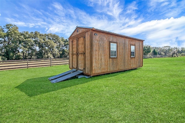 view of outbuilding featuring a yard and a rural view