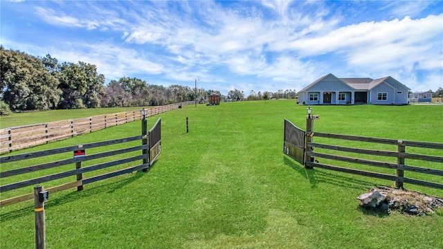 view of gate featuring a yard and a rural view