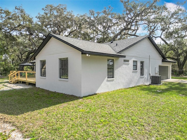 view of property exterior featuring a garage, a yard, a deck, and central air condition unit