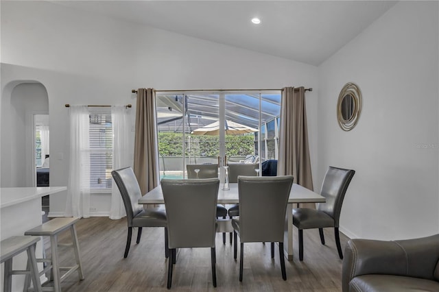 dining room with vaulted ceiling and wood-type flooring