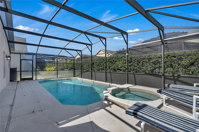 view of swimming pool with an in ground hot tub, glass enclosure, and a patio area