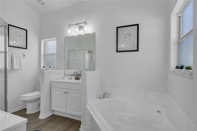 full bathroom with hardwood / wood-style flooring, toilet, vanity, and shower with separate bathtub