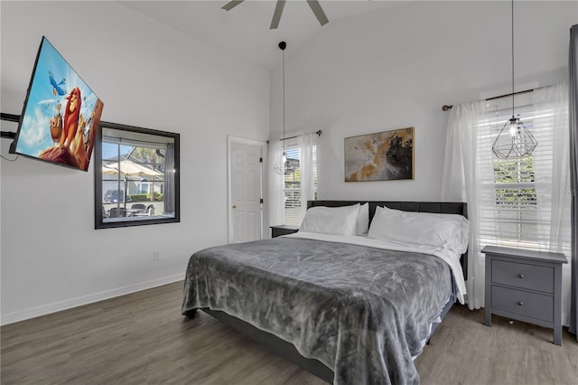 bedroom with hardwood / wood-style floors, high vaulted ceiling, and ceiling fan