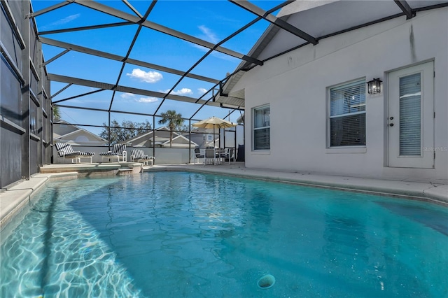 view of pool with a patio area and glass enclosure