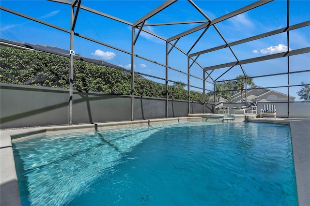 view of pool with a patio, glass enclosure, and a hot tub