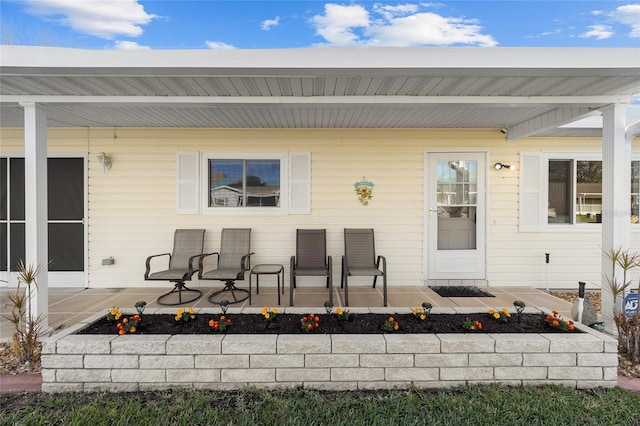 view of exterior entry featuring covered porch