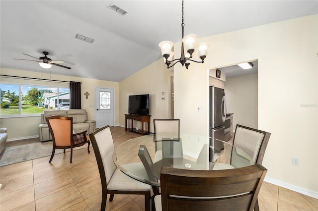 tiled dining area featuring vaulted ceiling and ceiling fan with notable chandelier