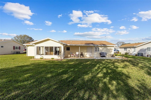 rear view of property featuring a patio and a lawn