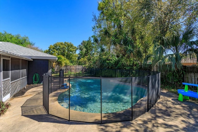 view of swimming pool featuring a fenced in pool, a patio, a fenced backyard, and a sunroom