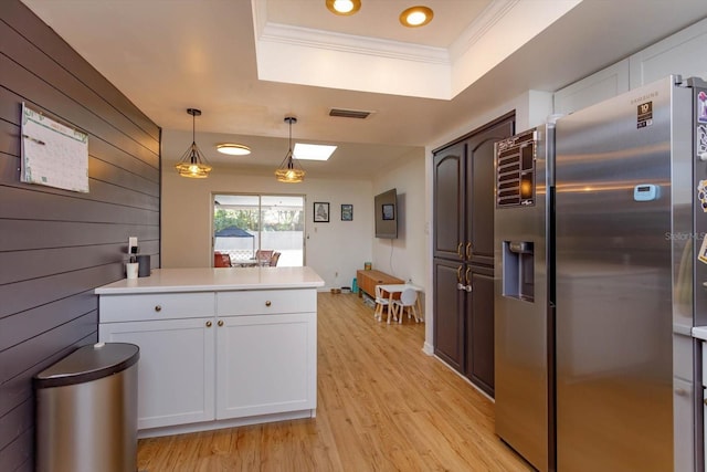 kitchen featuring ornamental molding, stainless steel refrigerator with ice dispenser, a tray ceiling, white cabinets, and light wood finished floors