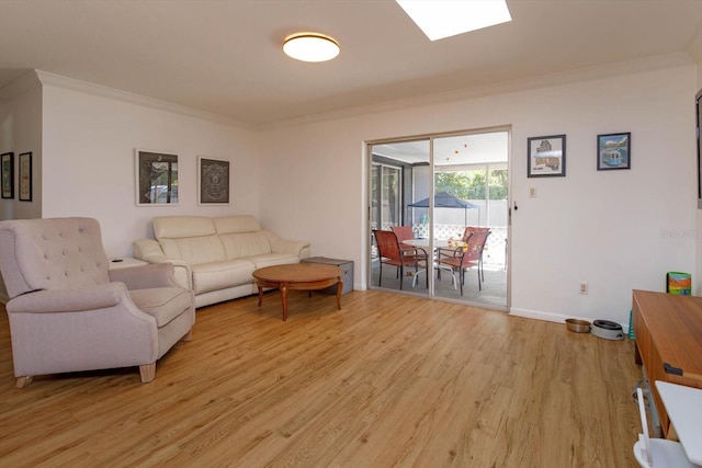 living room with baseboards, light wood-style floors, and crown molding