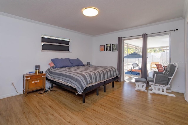 bedroom featuring access to exterior, baseboards, light wood finished floors, and ornamental molding