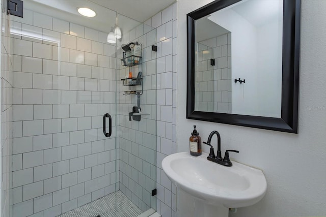 bathroom featuring a stall shower and a sink