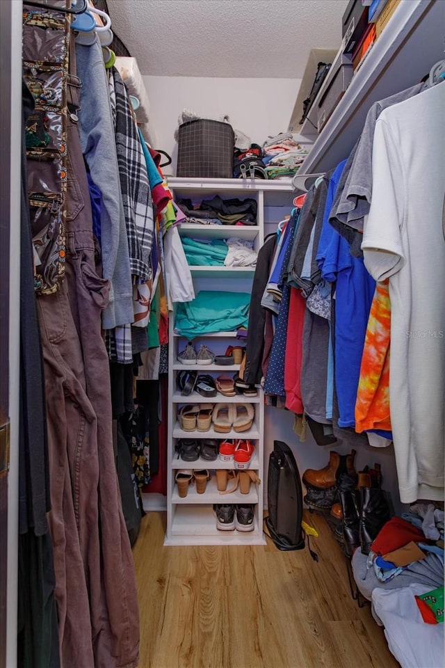 walk in closet with wood finished floors