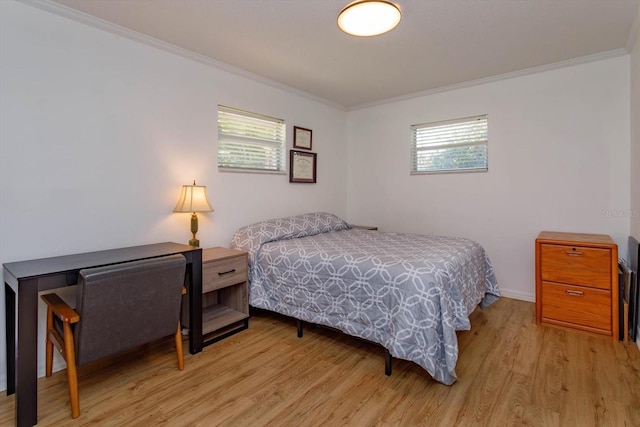 bedroom featuring crown molding, multiple windows, and light wood-type flooring