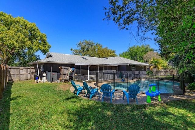 back of property with a fenced in pool, a sunroom, central AC unit, a fenced backyard, and a yard