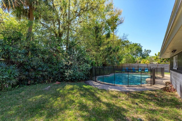 view of swimming pool featuring a lawn, a fenced in pool, and a fenced backyard