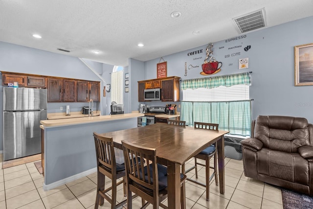 tiled dining area featuring a textured ceiling