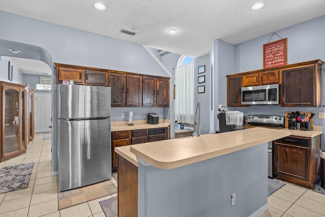 kitchen featuring light tile patterned flooring, a center island, and stainless steel appliances