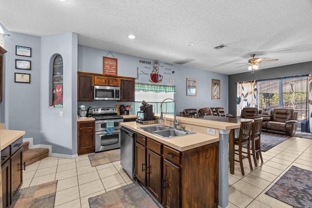 kitchen with a center island with sink, a healthy amount of sunlight, appliances with stainless steel finishes, and sink