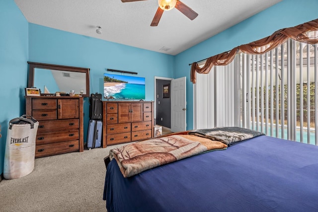 carpeted bedroom featuring a textured ceiling and ceiling fan