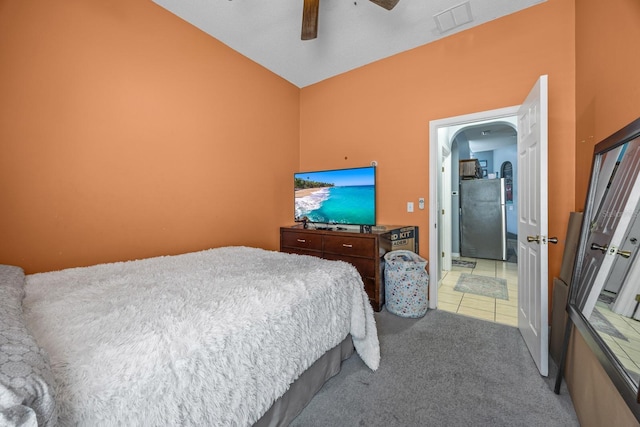 carpeted bedroom featuring ceiling fan and stainless steel refrigerator