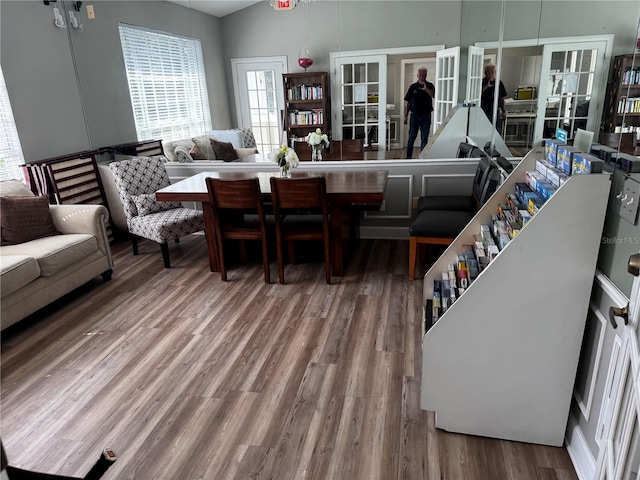 dining space with lofted ceiling, wood-type flooring, and french doors