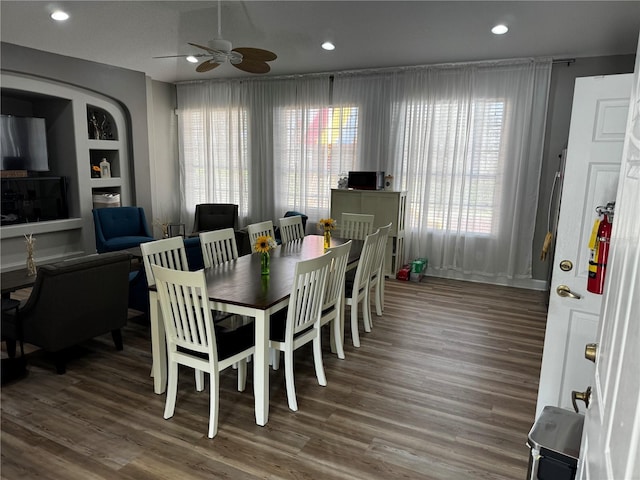 dining room featuring built in shelves, dark hardwood / wood-style floors, and ceiling fan