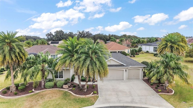 view of front of home with an attached garage, concrete driveway, a residential view, stucco siding, and a front yard