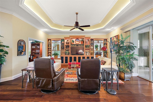 sitting room featuring ceiling fan, a tray ceiling, and dark wood-type flooring