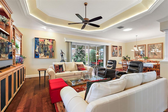 living room with ceiling fan with notable chandelier, dark wood-style flooring, visible vents, a tray ceiling, and crown molding