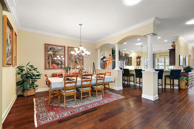 dining area featuring dark wood-style floors, baseboards, crown molding, and ornate columns