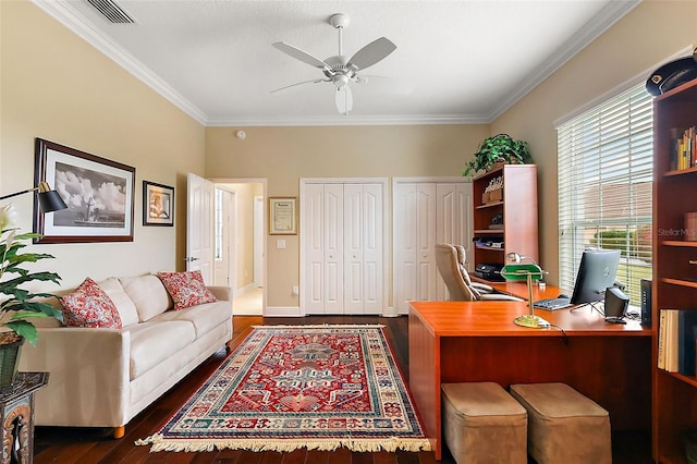 office space featuring visible vents, a ceiling fan, baseboards, ornamental molding, and dark wood-style floors