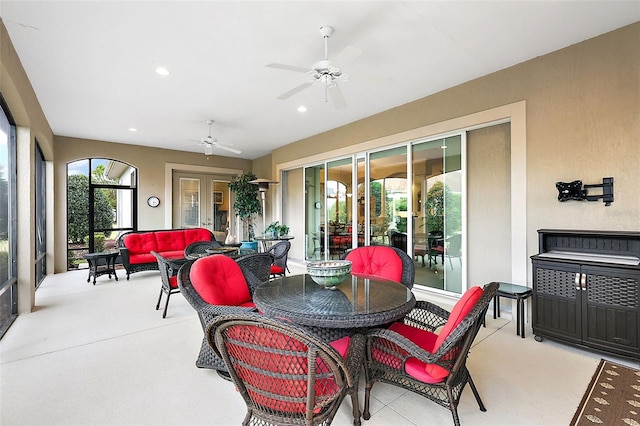 sunroom / solarium featuring french doors, plenty of natural light, and a ceiling fan