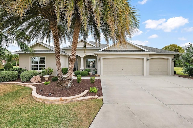 view of front of house with an attached garage, driveway, a front yard, and stucco siding