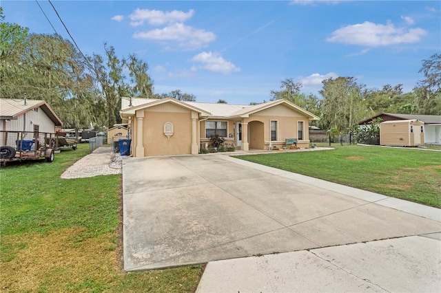 ranch-style house featuring a storage unit and a front lawn